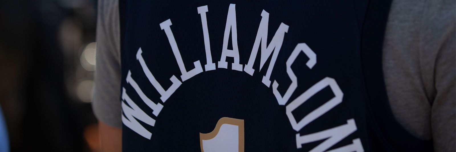 The back of a man wearing Nike Men's New Orleans Pelicans Zion Williamson #1 Navy Dri-FIT Swingman Jersey.