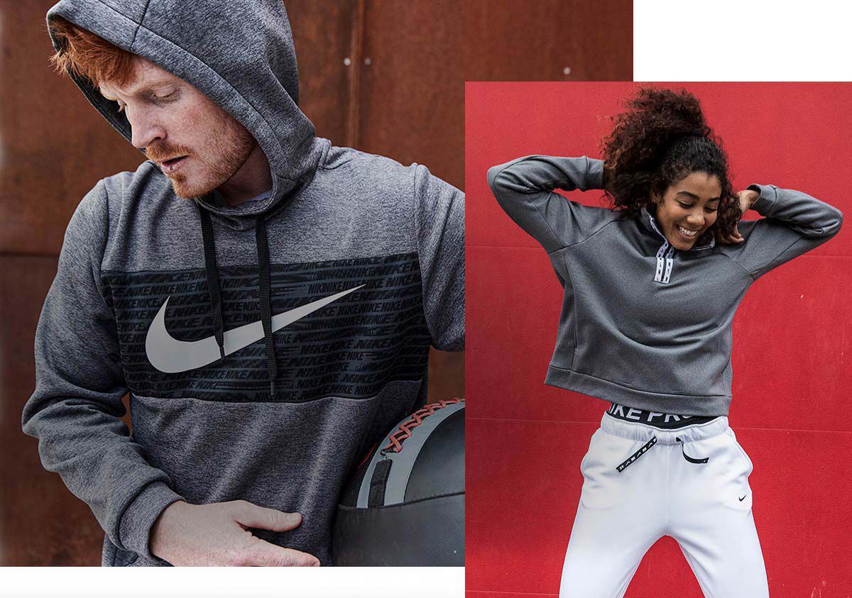 A man wearing the Nike Therma Pullover Hoodie, and a woman wearing the Nike All Time Half-Zip Pullover and Nike Sportswear Essential Fleece Pants.