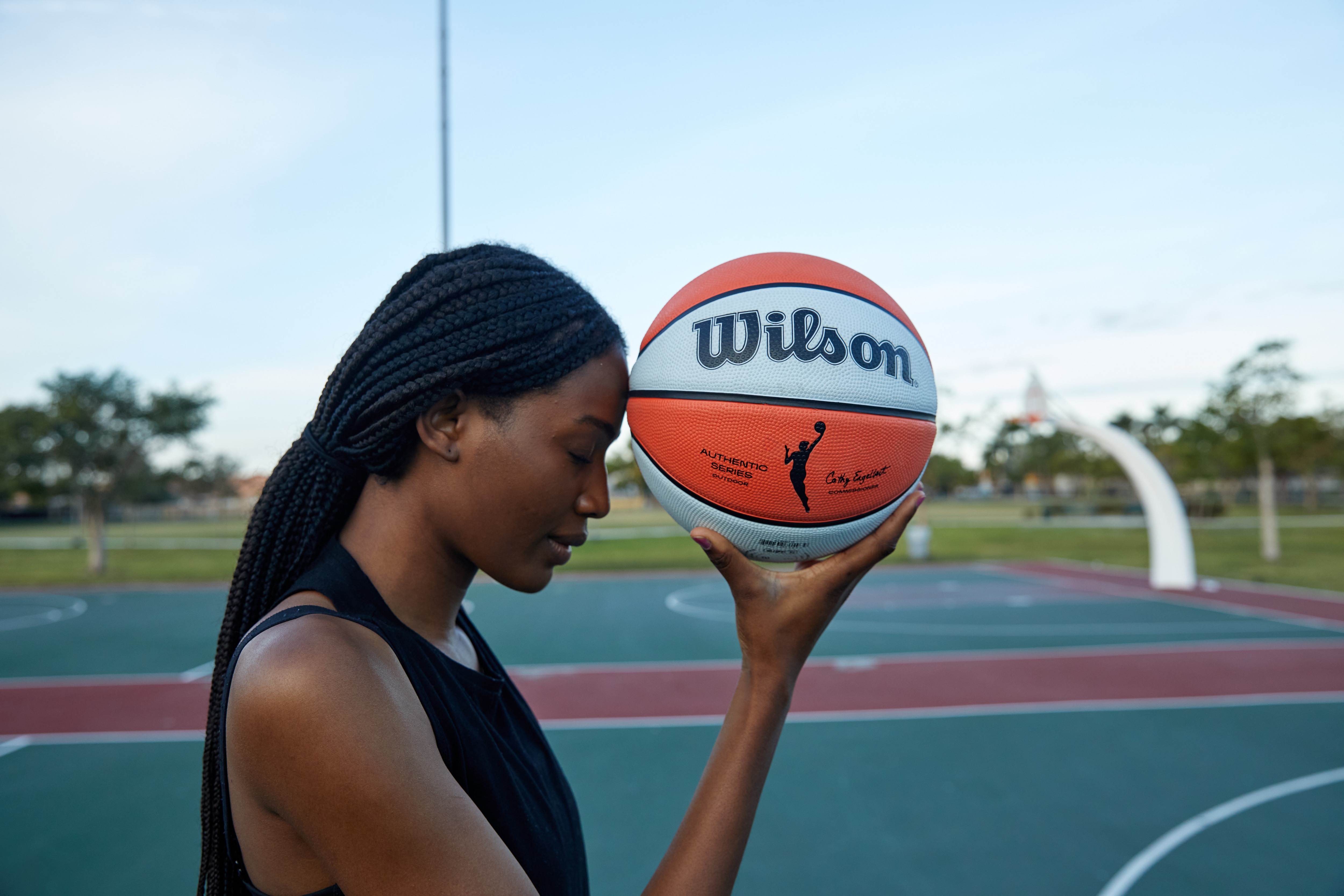 Women holding Wilson WNBA Authentic Indoor/Outdoor Basketbal