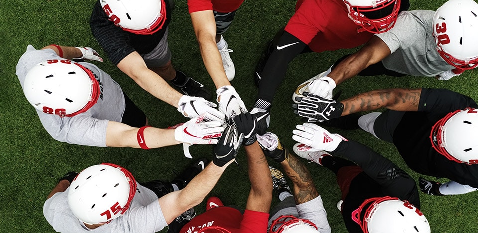 A group of football players in a huddle.