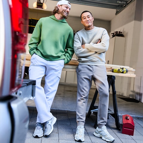 Two friends standing in a garage.