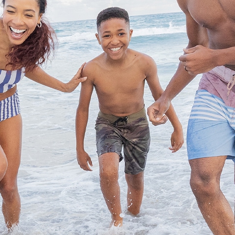 A boy on the beach with his family.