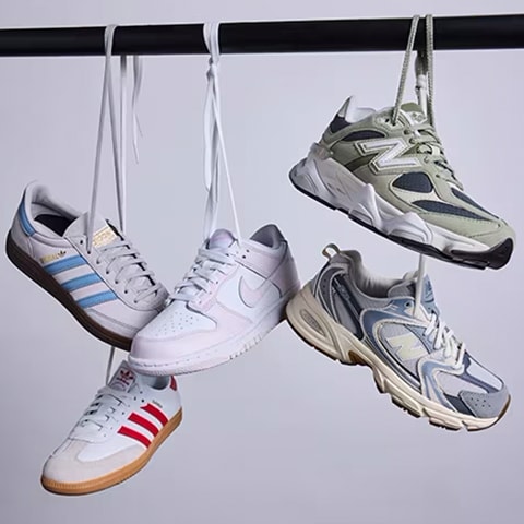 Collection of shoes hanging from shoe laces.