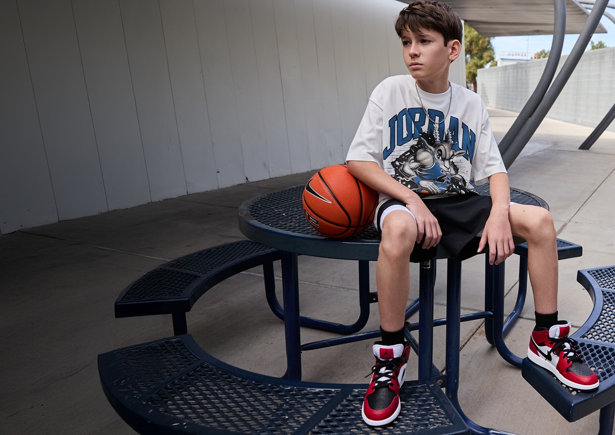 A boy sitting on a park table.