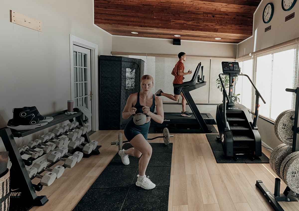 Two people exercising in a home gym