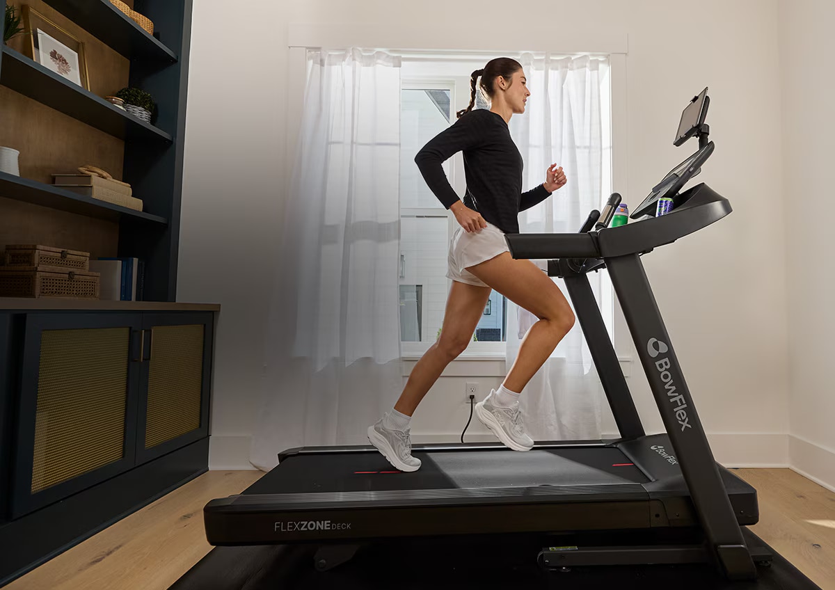 A woman running on a treadmill at home