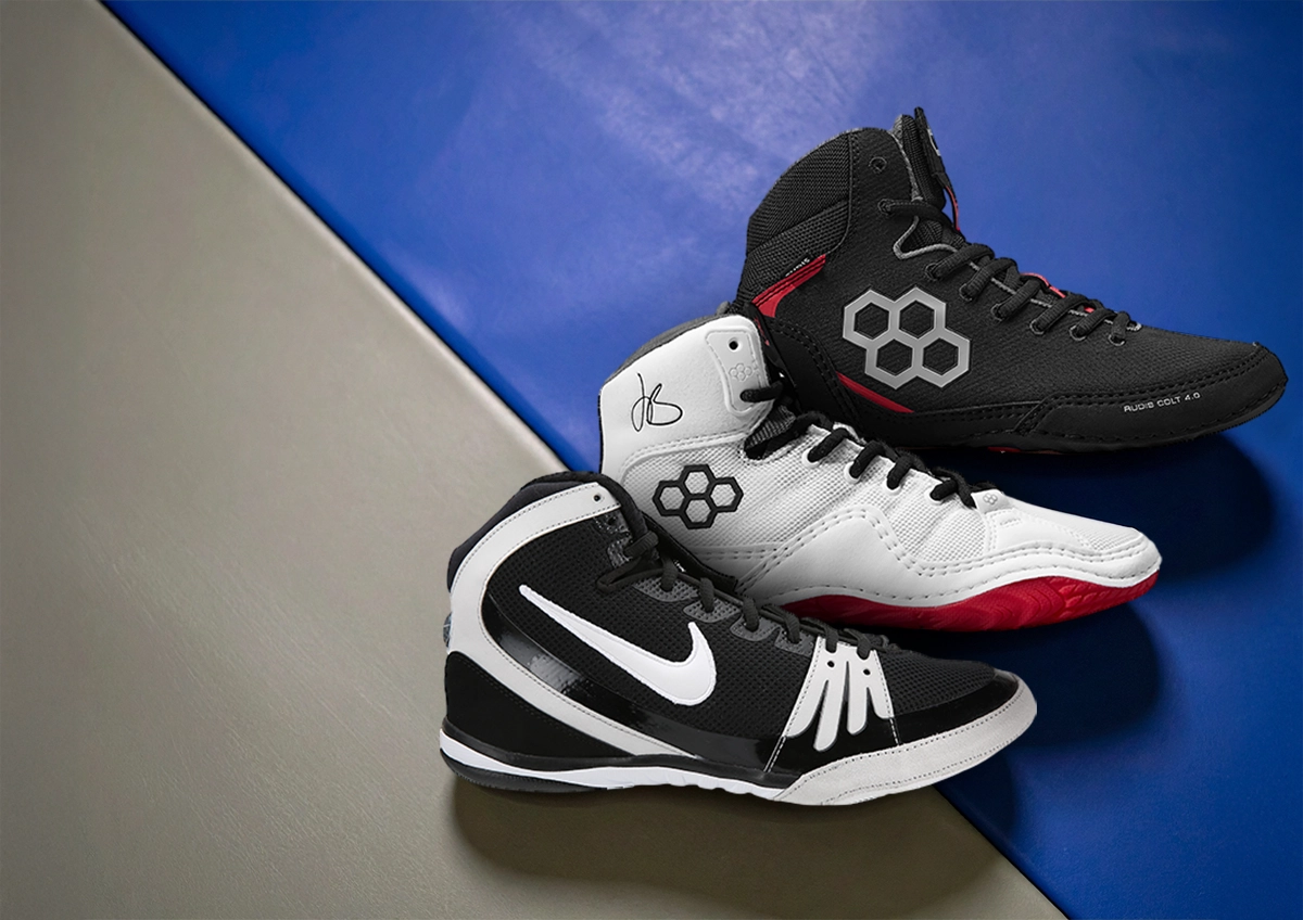 Collection of wrestling shoes on a wrestling mat.