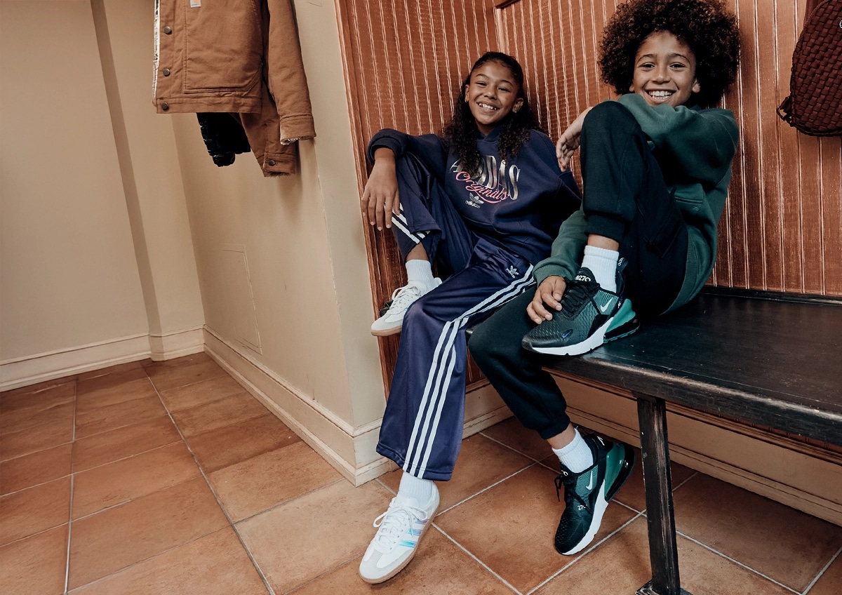 Boy and girl sitting on a bench inside.