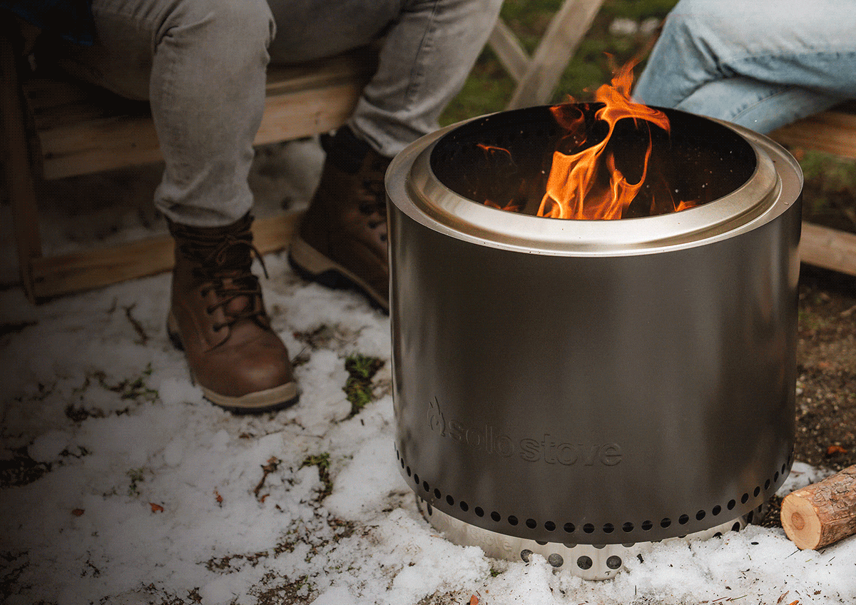People huddled around a solo stove.