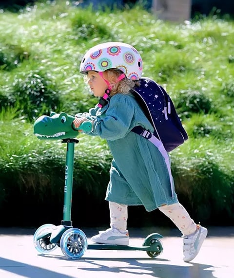 A little girl riding a scooter