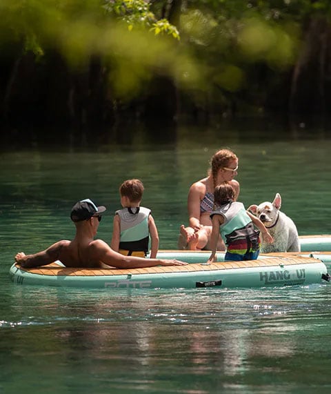 family in the water in a bote hammock