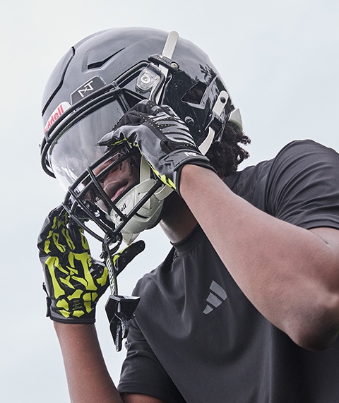 Football player adjusting helmet.