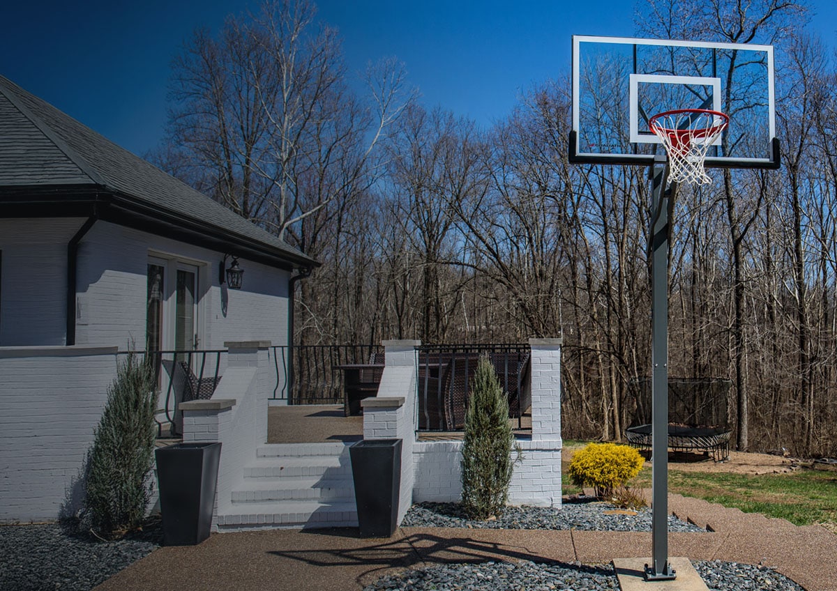 Basketball hoop mounted by house.