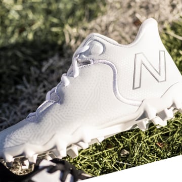 Close up of lacrosse cleats sitting in grass.