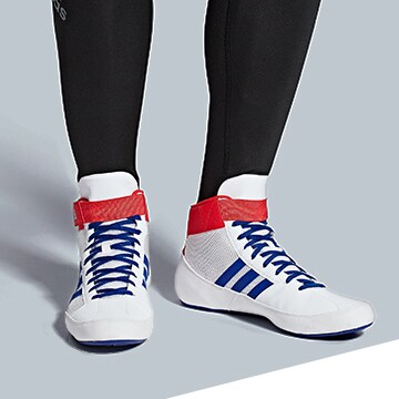 Close up of someone standing in wrestling and boxing shoes.