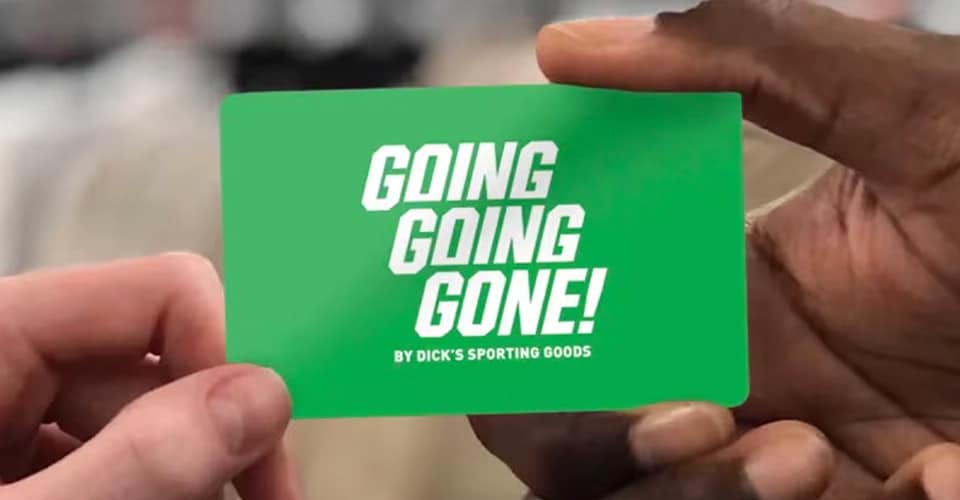 Two people handing off a Going Going Gone gift card.