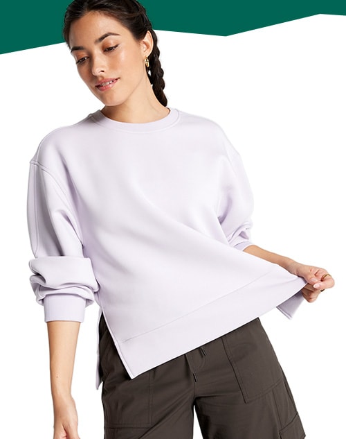 Woman standing in a sweatshirt.