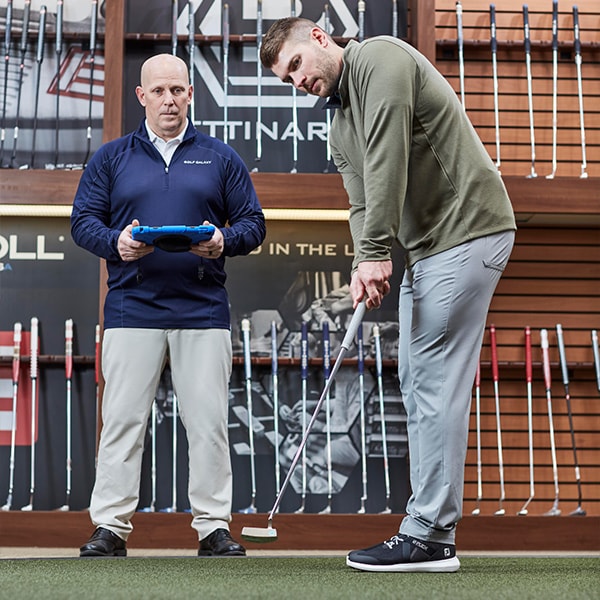 An Image Of A Golfer Being Fitted For A Putter