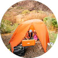 Family in a tent outdoors.
