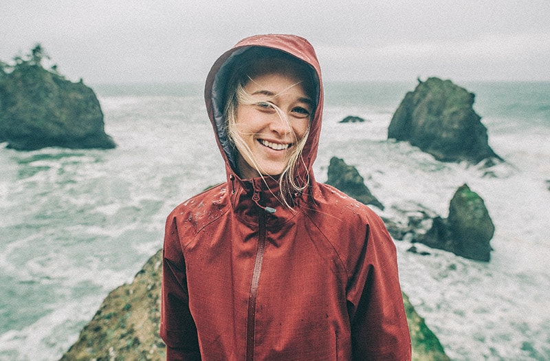 Person on rock near body of water.