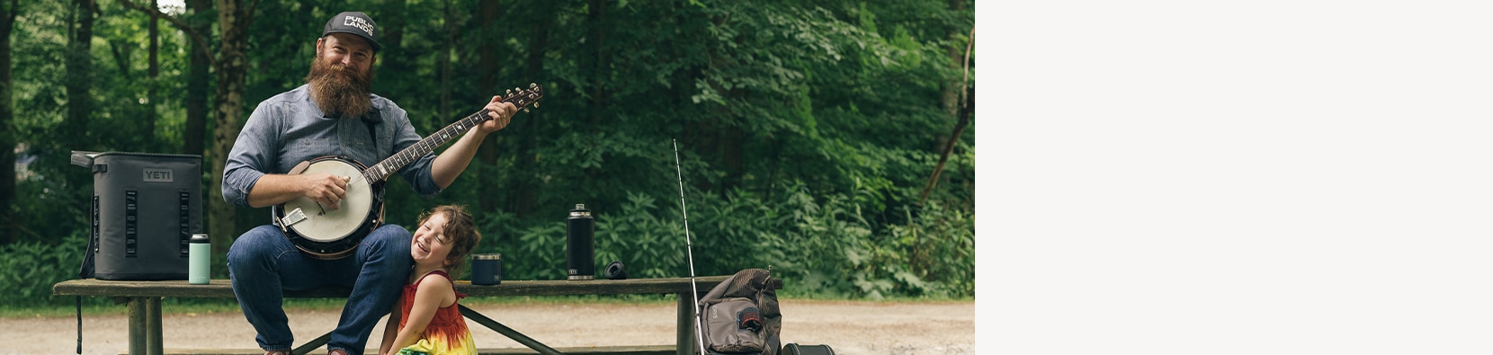 man playing banjo with daughter beside him