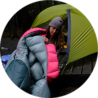 woman in sleeping bag outside of tent