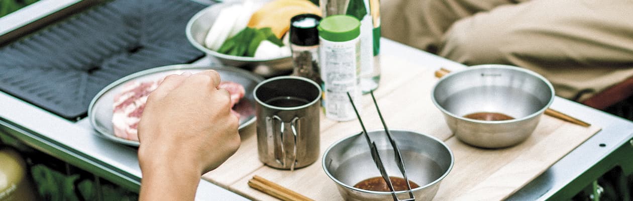 Campers prepping a meal using Snow Peak cookware.