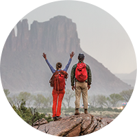 two people backpacking around mountains