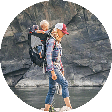 A woman carrying a child in a child carrying backpack