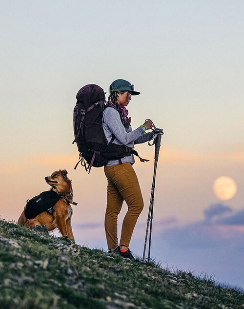 A woman hiking with her dog