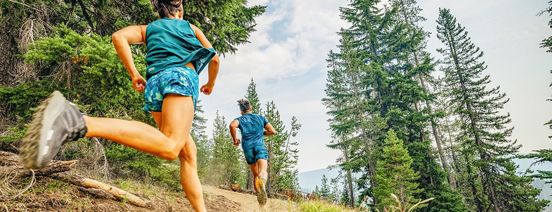 Two people running on a dirt trail