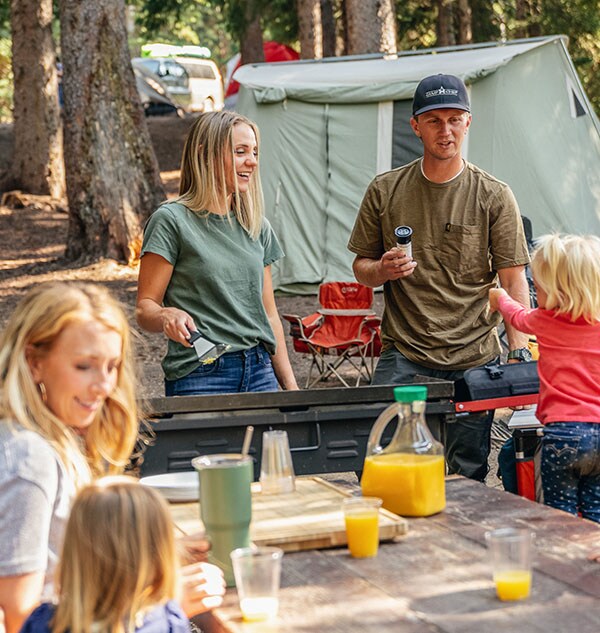 A family cooking breakfast outdoors.