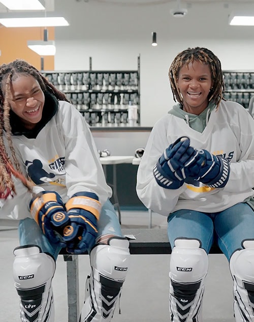 Two girls in hockey equipment