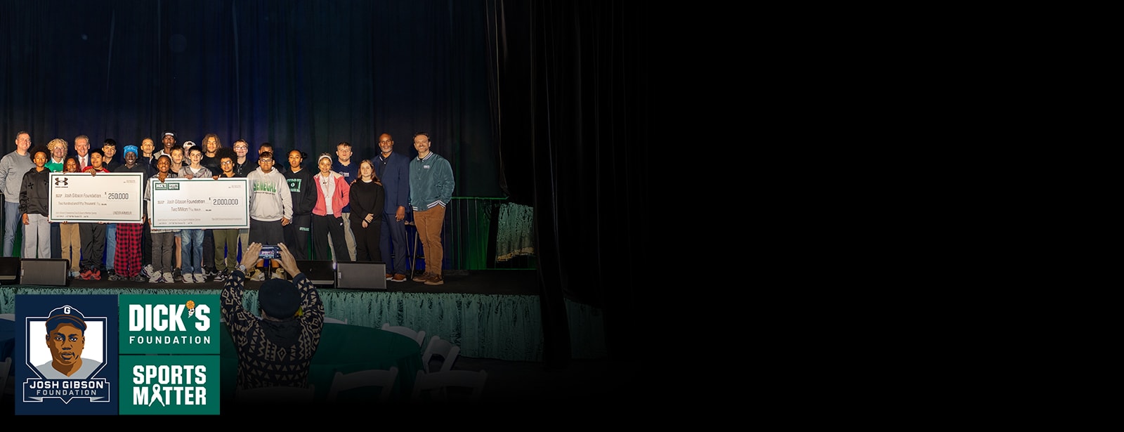 Young athletes holding a large check on stage