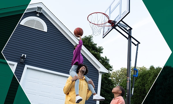 Family playing basketball outdoors.