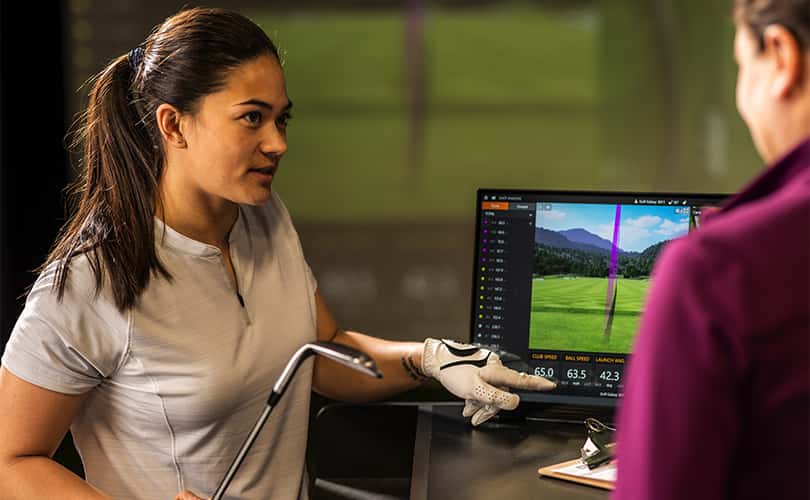A Female Golfer Getting Fitted For Golf Clubs